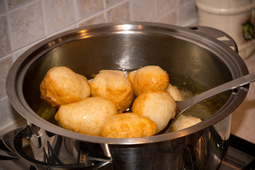 Dipper taking off Dough from a Pot after Friying during the Preparation of an Italian Christmas Traditional Dish called Pettole