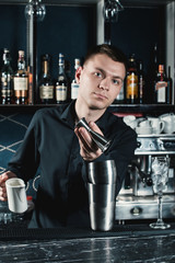 bartender making Green Alcoholic Cocktail pouring fluid into glass.