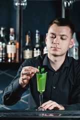 bartender making Green Alcoholic Cocktail. bar on a background