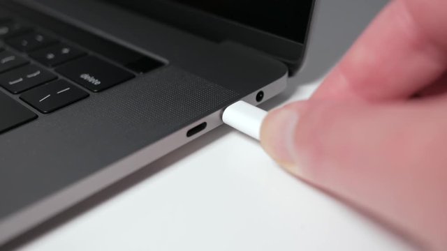 White USB-C / USB Type C cable plugged into modern laptop
