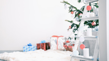 Stylish white christmas interior with decorated fir tree with gift boxes