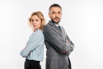 confident professional businessman and businesswoman standing with crossed arms and looking at camera isolated on white