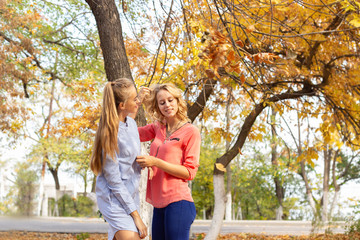 Fototapeta premium Summer autumn vacation, holidays, travel and people concept - group of young women in the park
