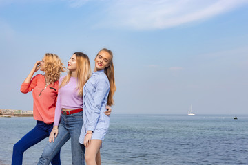 Fototapeta na wymiar Portrait of three young female friends walking near sea