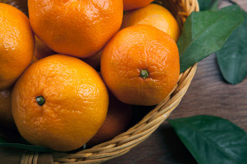 bunch of fresh tangerines or mandarins in the basket and leaves