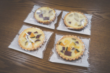 wrapped sweet pumpkin and sweet potato pies on wooden table