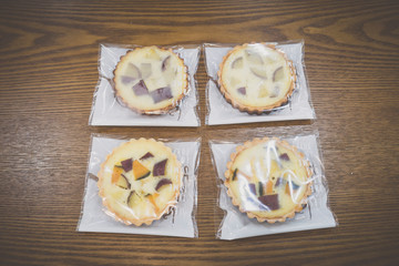 wrapped sweet pumpkin and sweet potato pies on wooden table