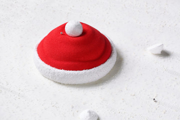 Santa Claus Hat - Contemporary Strawberry Mousse Cake, on white plate, on white background.