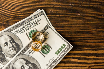 top view of cash and wedding rings on wooden table