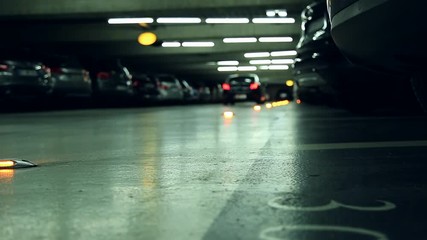 Panning shot of a car leaving an underground parking garage. Shallow D.O.F.