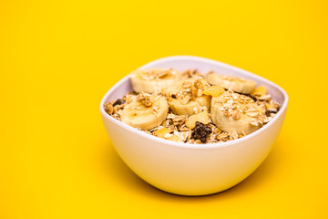 A bowl with banana, oats and cereal.
