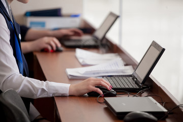 Human hand on computer mouse. Laptop on desk.