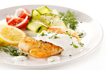 Fried cod and vegetables on white background