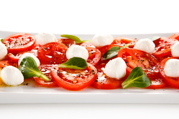 Caprese salad - mozzarella and tomatoes on white background