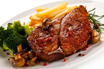 Grilled beefsteak with french fries and broccoli on white background