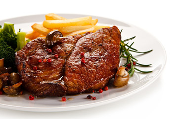 Grilled beefsteak with french fries and broccoli on white background