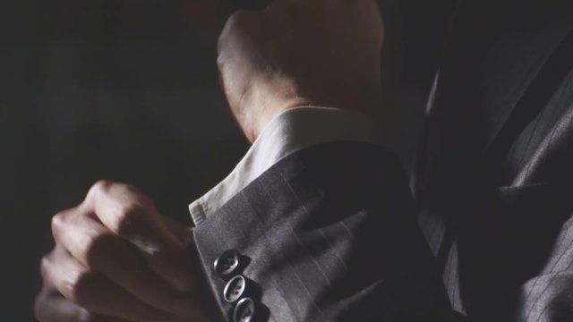 close up of Asian businessman in formal wear adjusting sleeves