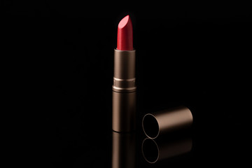 Luxury lipstick isolated on black background. Red lipstick.
