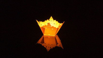 CLOSE UP: Colorful lamp floats around the tranquil river on festive night. © helivideo