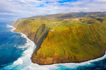 Aerial Madeira island view with Atlantic ocean, white waves, cliffs and green nature