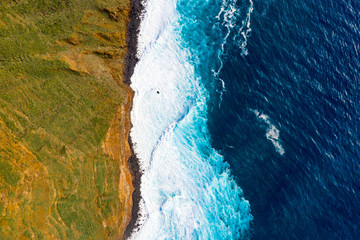 Aerial Madeira island view with Atlantic ocean, white waves, cliffs and green nature