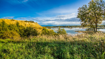 Sandy hills. Lake in the Sandy canyon. Warm colors background. Yellow sandstone textured mountain,...