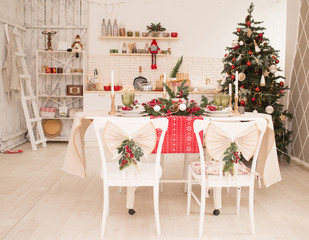 Interior light kitchen and red christmas decor. Preparing holiday dinner at home on the kitchen concept. Decorated new Year fir. Selective focus