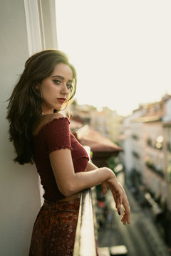 Charming young brunette lady on balcony