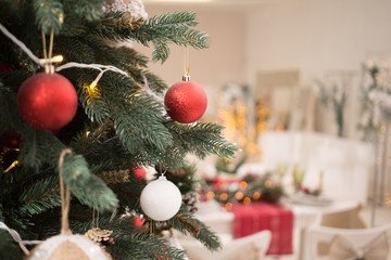 Interior light kitchen and living room with red christmas decor. Preparing holiday dinner at home on the kitchen concept. Decorated new Year fir. Selective focus