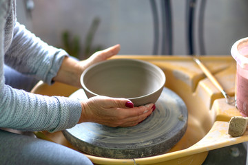 Womans hands on pottery workshop working with clay