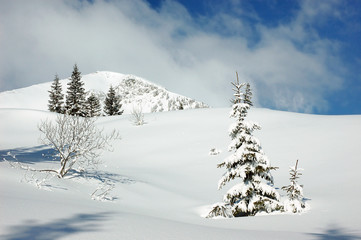 Winter mountain landscape with snow covered road forest hills snow and blue sky with clouds