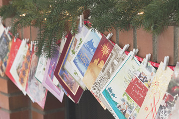 Christmas photograph of Christmas cards strung over a fireplace mantel - obrazy, fototapety, plakaty