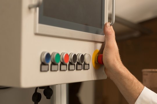 Robotics engineer controlling control panel in warehouse