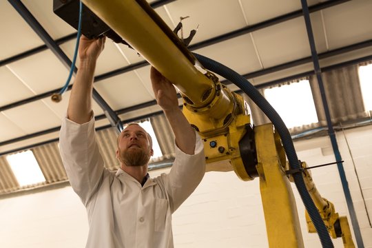 Robotics engineer operating robotic machine