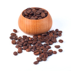 Roasted coffee beans in wooden cup on a white background