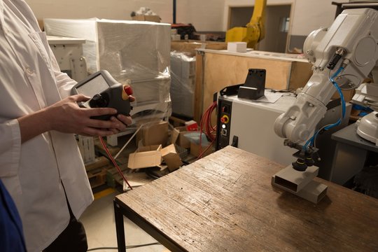 Robotic engineers operating robotic machine with remote control - Powered by Adobe