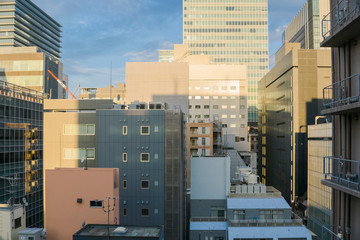 Japanese abstract urban background featuring details of chaotic city buildings in Tokyo downtown in Ginza district at sunrise in November.   