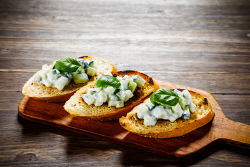 Bruschettas on cutting board on wooden background