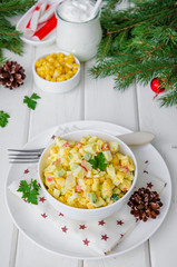 Traditional Russian salad with crab sticks, fresh cucumbers, corn and boiled eggs in a bowl