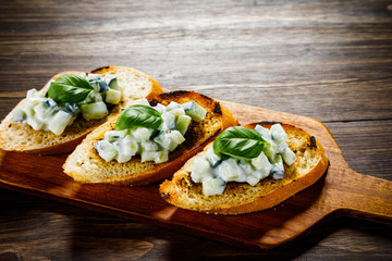 Bruschettas on cutting board on wooden background