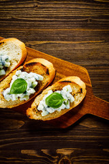 Bruschettas on cutting board on wooden background