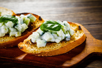 Bruschettas on cutting board on wooden background