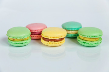 Sweet almond colorful pink, blue, yellow, green macaron or macaroon dessert cake isolated on white background. French sweet cookie. Minimal food bakery concept. Flat lay, top view, copy space