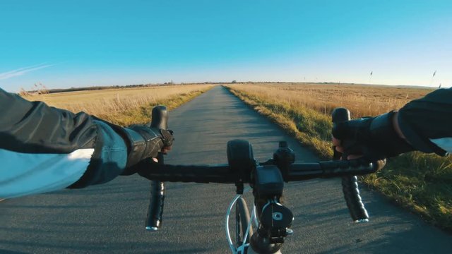 Point of view of athlete riding racing bicycle and turing left on small road