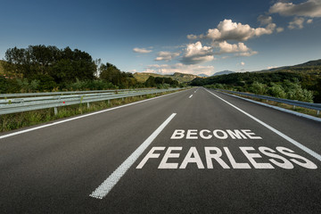 Become Fearless message on Asphalt highway road through the countryside to the mountains