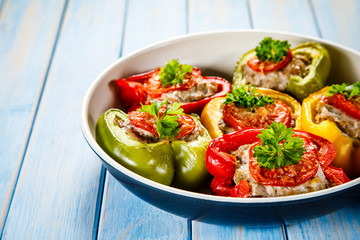 Stuffed peppers in frying pan on wooden table