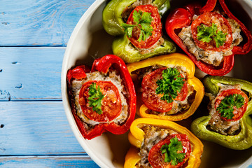 Stuffed peppers in frying pan on wooden table