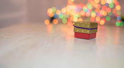 Christmas gifts or present boxes. Colorful lights, globes and decorations in the background, on rustic wooden surface. Christmas stocking with the 