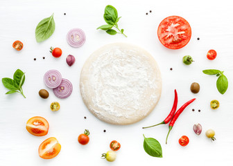 The ingredients for homemade pizza on white wooden background.