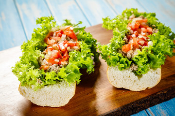 Sandwiches with meat and vegetables on cutting board